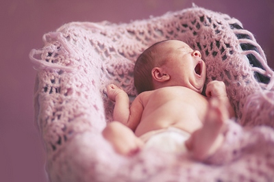 Portrait of a cute newborn baby girl lying down on a blanket